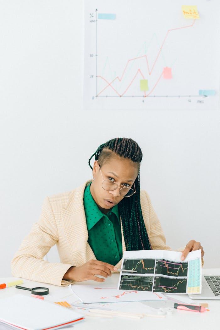 Businesswoman in office analyzing financial data with charts and graphs.